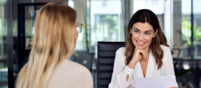 Businesswoman smiling during a professional meeting in a modern office.