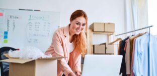 Small business owner reviewing documents on the laptop at the workplace