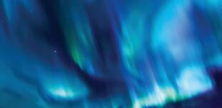 Aurora lights sweeping across a dark night sky in vivid blue, teal and green, with scattered stars visible through the glow.